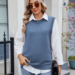 Detail view of blue knitted vest with side button decoration and white shirt layer.