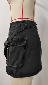 Detail view of washed black denim cargo skirt with large utility pocket and buckle