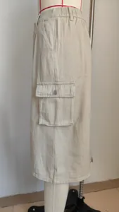 Close-up detail of the side cargo pocket and washed denim fabric on a beige midi skirt