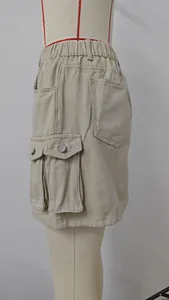 Detail view of khaki washed denim cargo mini skirt featuring multi-pockets and elastic waist.