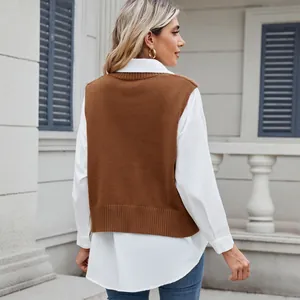 Back view of a casual women's brown knitted vest styled over a crisp white long sleeve shirt