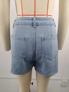 Close-up detail of light blue washed denim shorts back pockets and belt loops