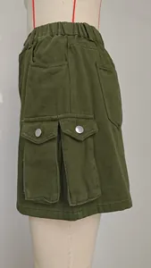 Detail of olive green cargo denim skirt with large flap pockets and metal buttons