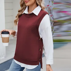 Detail of the side button closure and split hem on a burgundy knit sweater vest.