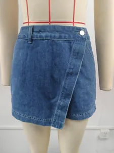 Detail view of irregular washed denim skort with front overlap and silver metal button detail.