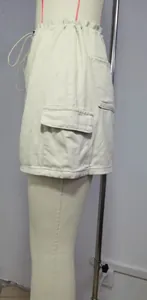 Close-up side view of beige denim cargo mini skirt with functional flap pocket