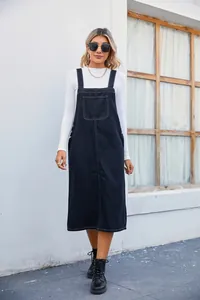 Outdoor street style detail of a dark denim overall midi dress with contrast stitching