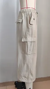 Side view of a khaki denim cargo midi skirt featuring a functional flap pocket detail.