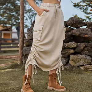 Detail shot of beige cargo midi skirt featuring large side pockets and drawstring hem.