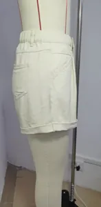 Vue latérale détaillée d'un short en jean crème avec taille élastique sur un mannequin