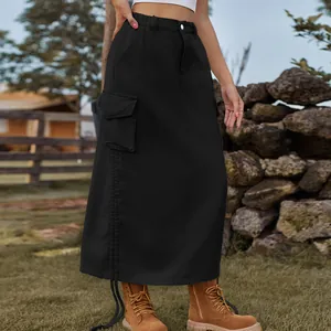 Side view detail of a black denim cargo maxi skirt with utility pockets in outdoor setting.