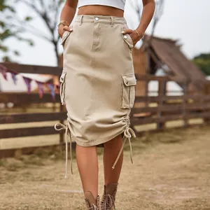 Detail view of khaki cargo midi skirt featuring large pockets and adjustable drawstring hem.