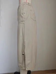Dettaglio della vista laterale di gonna midi in denim beige con vita elastica e coulisse