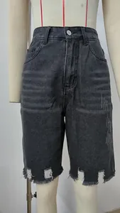 Detailed view of high-waisted distressed denim shorts with frayed hems on a mannequin
