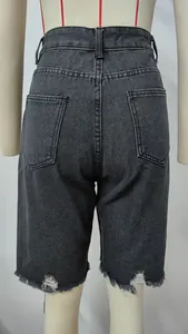 Back view detail of distressed black denim shorts with raw fringe hem and pockets.