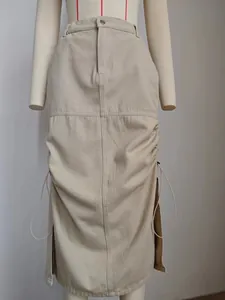 Dettaglio di una gonna midi in denim kaki lavato con coulisse laterale e spacco.