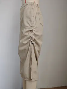 Dettaglio di gonna midi in denim lavato con coulisse laterale regolabile ed elastico in vita.