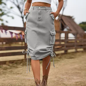 Macro detail of a grey mid-length denim cargo skirt featuring drawstring hems and pockets