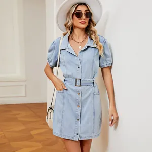 Close-up view of a light blue washed denim dress featuring a belt and puff sleeves
