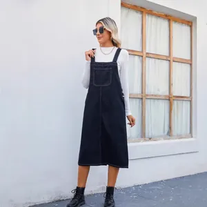 Chic outdoor fashion photo of a stylish black denim overall midi dress with front pocket
