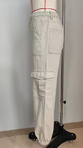 Detail view of beige high-waisted women's cargo pants with large side flap pockets.