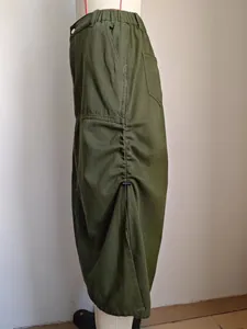 Dettaglio di gonna cargo in denim verde oliva con coulisse laterale regolabile