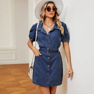 Detail view of a washed blue denim dress with short puff sleeves and matching belt.