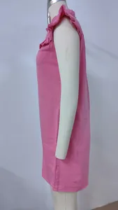Side view of a pink sleeveless washed denim dress featuring ruffle details on the collar