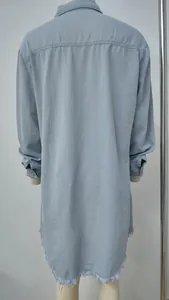 Vista posterior detallada de un vestido camisero de mezclilla azul claro con bajo deshilachado