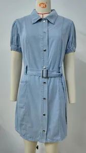 Detailed shot of a light blue washed denim dress featuring a waist belt and metal buttons.