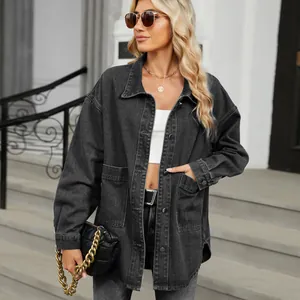 Detailed view of women's oversized washed black denim jacket in a street style setting