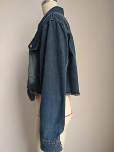Detailed side profile of a stylish washed blue cropped denim jacket featuring raw hem edges