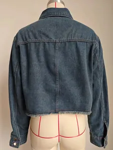 Back view of a washed blue cropped denim jacket featuring a raw frayed hem detail