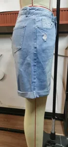 Vue détaillée d'un bermuda en jean bleu clair délavé avec revers sur un mannequin de couture