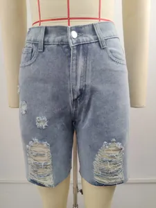 Vintage mid-waist light blue denim shorts with heavy ripped and distressed hole details