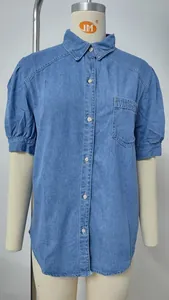 Detalle de una camisa vaquera azul claro con mangas abullonadas y un bolsillo en el pecho.