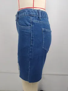 Side view of vintage mid-waist denim shorts with distressed raw hem details