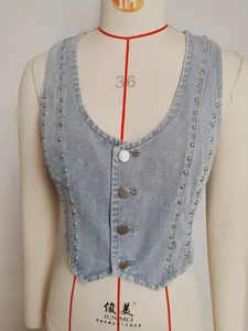 Detail view of retro washed denim vest featuring silver metal studs and V-neckline