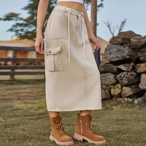 Detail of a beige washed denim cargo midi skirt with drawstring waist and boots