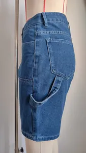 Detalle de vista lateral de pantalones cortos de carpintero de mezclilla azul lavada para mujer
