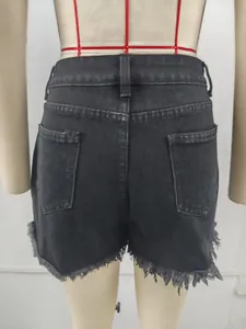 Detailed back view of black distressed denim shorts with frayed raw hem on mannequin