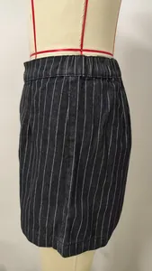 Detail view of black denim shorts featuring white vertical stripes and elastic waistband