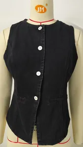 Detailed close-up of a black washed denim sleeveless vest with white buttons on a mannequin