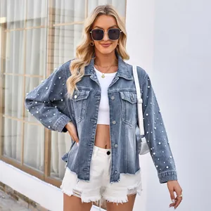 Detailansicht einer modischen blauen Jeansjacke mit eleganten Perlenverzierungen