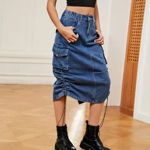 Détail d'une jupe midi cargo en denim avec poches latérales et ourlet réglable.