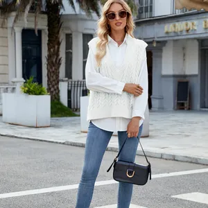 Street style detail of woman wearing a white V-neck cable-knit sweater vest outdoors