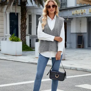 Women's grey cable-knit V-neck sweater vest over a white shirt in street setting