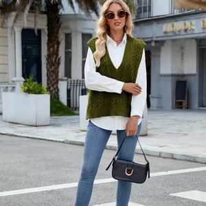 Detailed shot of an olive green cable knit V-neck sweater vest styled with a white shirt.