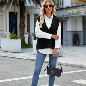 Close-up of black cable-knit V-neck sweater vest paired with a white button-down shirt