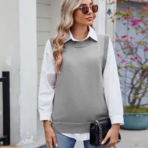 Close-up street style view of a gray knit vest layered over a white long-sleeve shirt